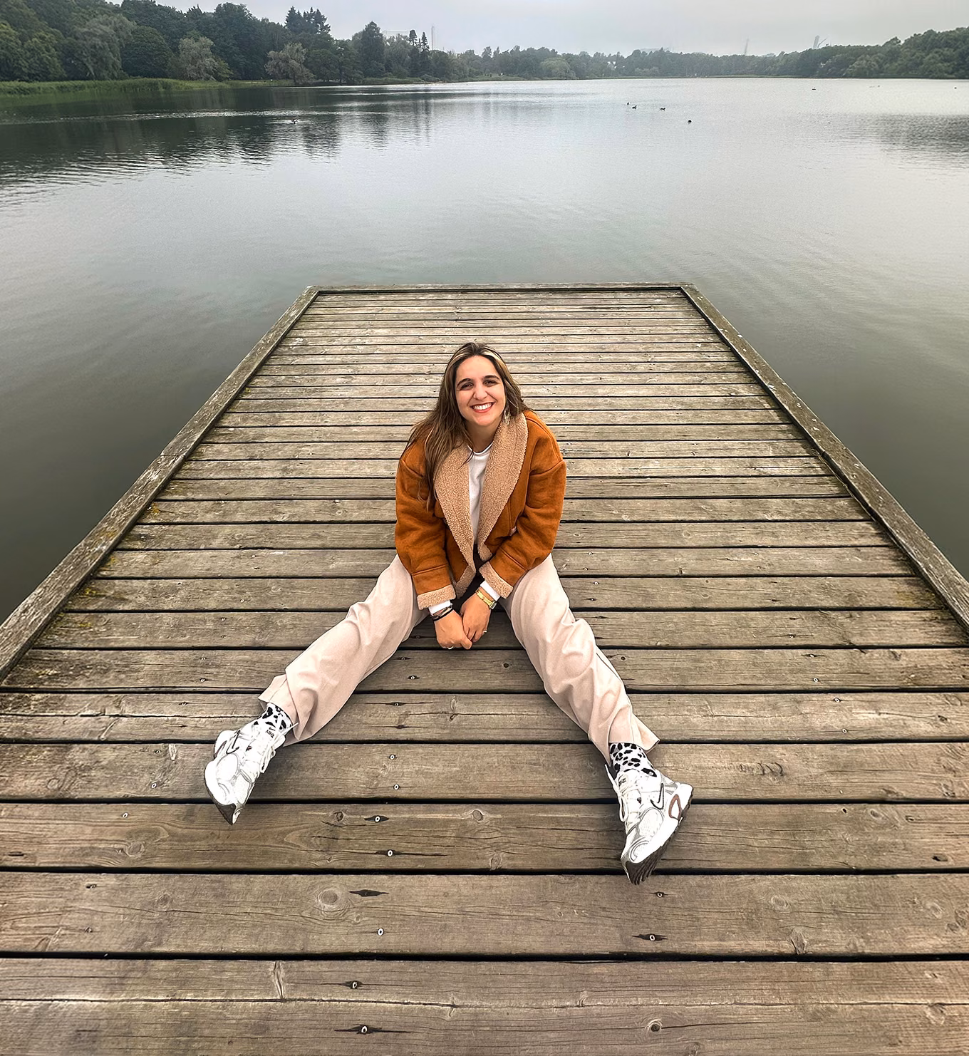 Efstathia Chatzitheodorou sitting on a lakeside dock